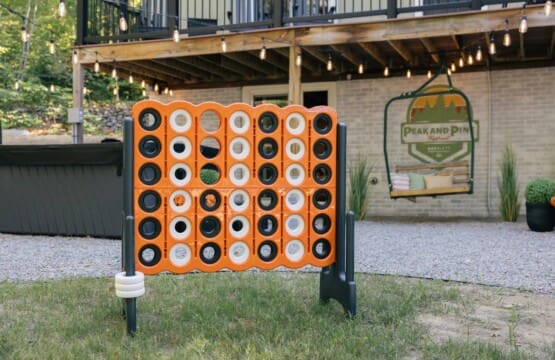 Giant Connect Four lawn game in the backyard at Peak and Pine Retreat with string lights