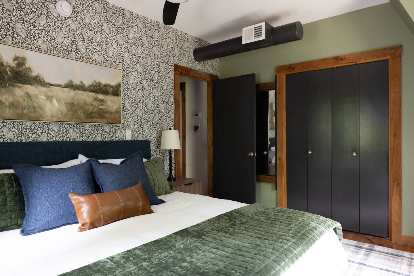 Stylish bedroom with botanical wallpaper and velvet bedding at Peak and Pine Retreat luxury cabin