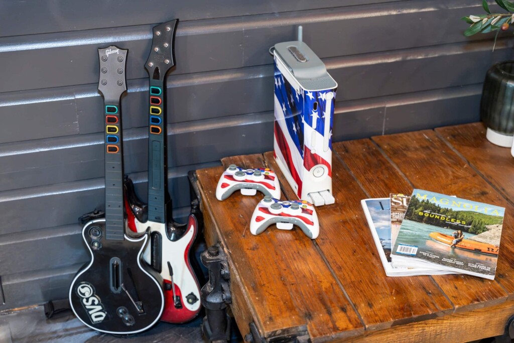 Guitar Hero controllers and Xbox console on a rustic wooden table
