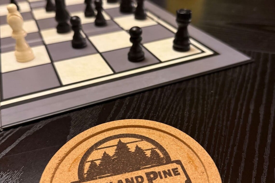 Chess board and Peak and Pine coaster on the game table