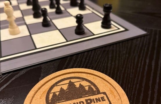 Chess board and Peak and Pine coaster on the game table