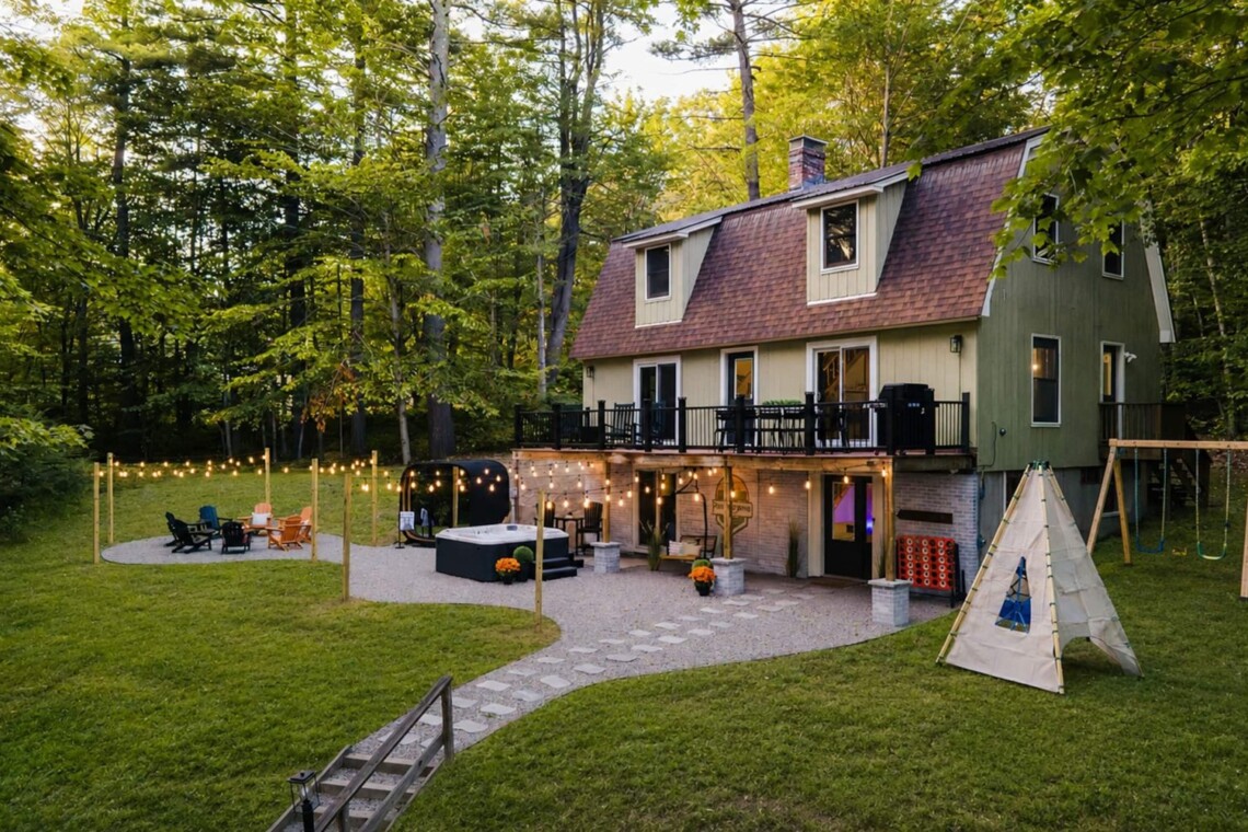 Back of the house at evening with string lights at Peak & Pine Retreat