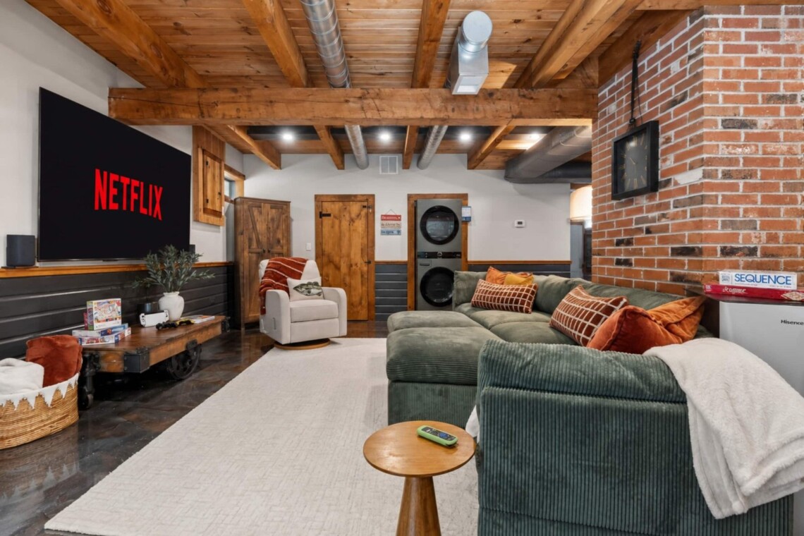 Family room with sectional sofa and stacked washer and dryer at Peak & Pine Retreat