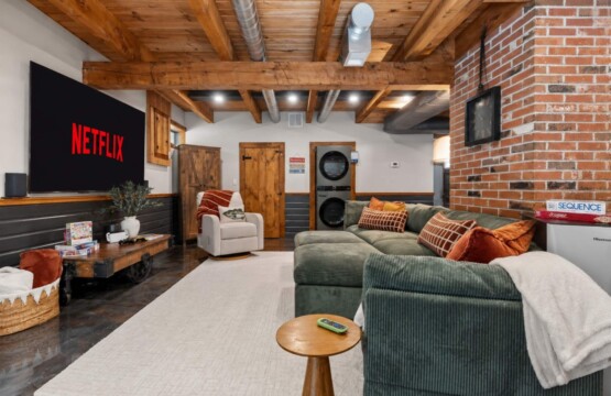 Family room with sectional sofa and stacked washer and dryer at Peak & Pine Retreat
