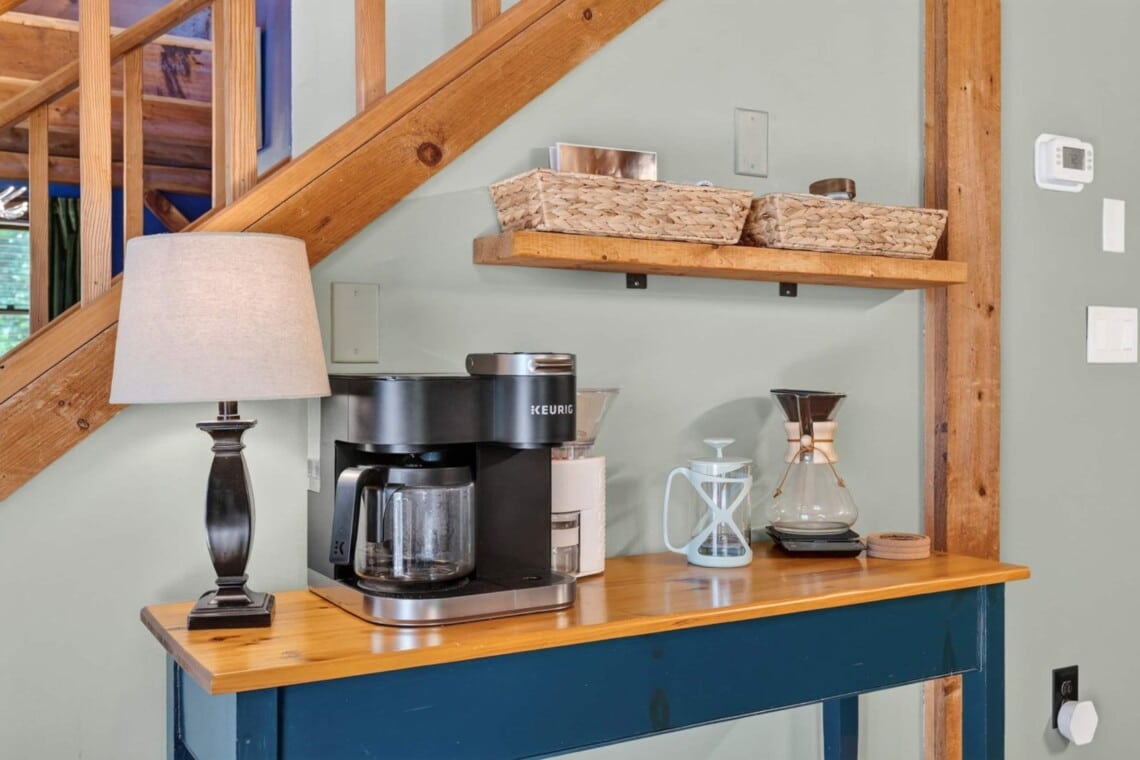 Coffee station with coffee maker, pour-over carafe and lamp under the stairs