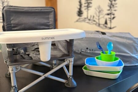 Portable booster seat with kids' dishes set up at the dining table