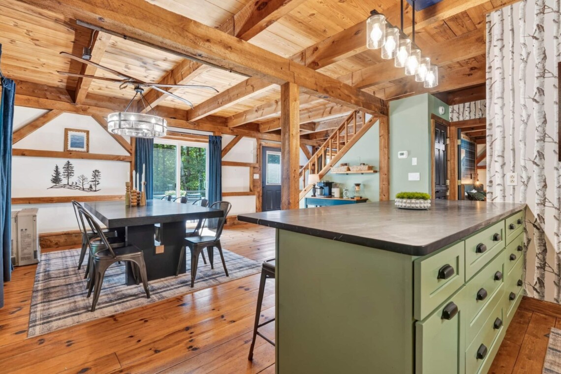 Open timber-frame kitchen island and dining area with exposed wood beams