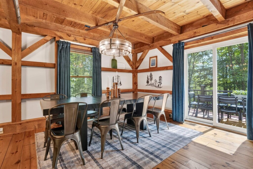 Dining table with metal chairs, chandelier and sliding doors to the deck