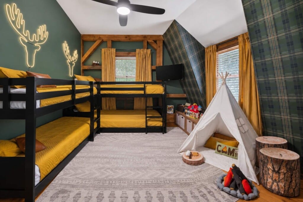 Bunk room with two black bunk beds sleeping four and a kids teepee