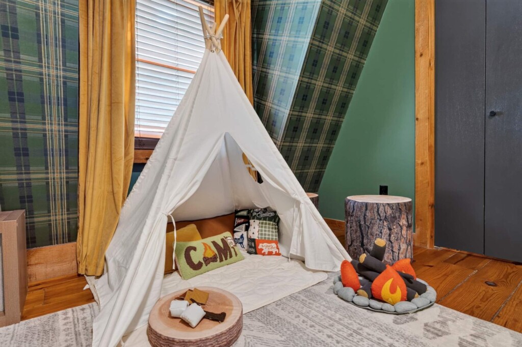 Kids teepee play corner with plush campfire in the plaid bunk room