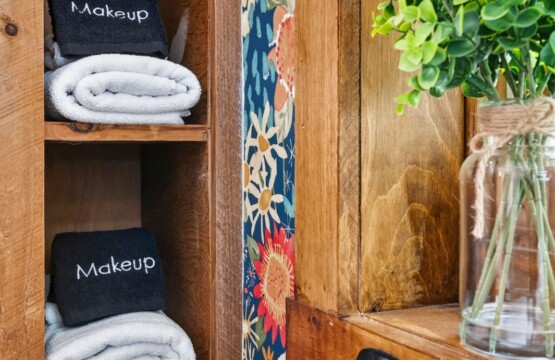 Open shelves with rolled towels and makeup remover cloths in the bathroom