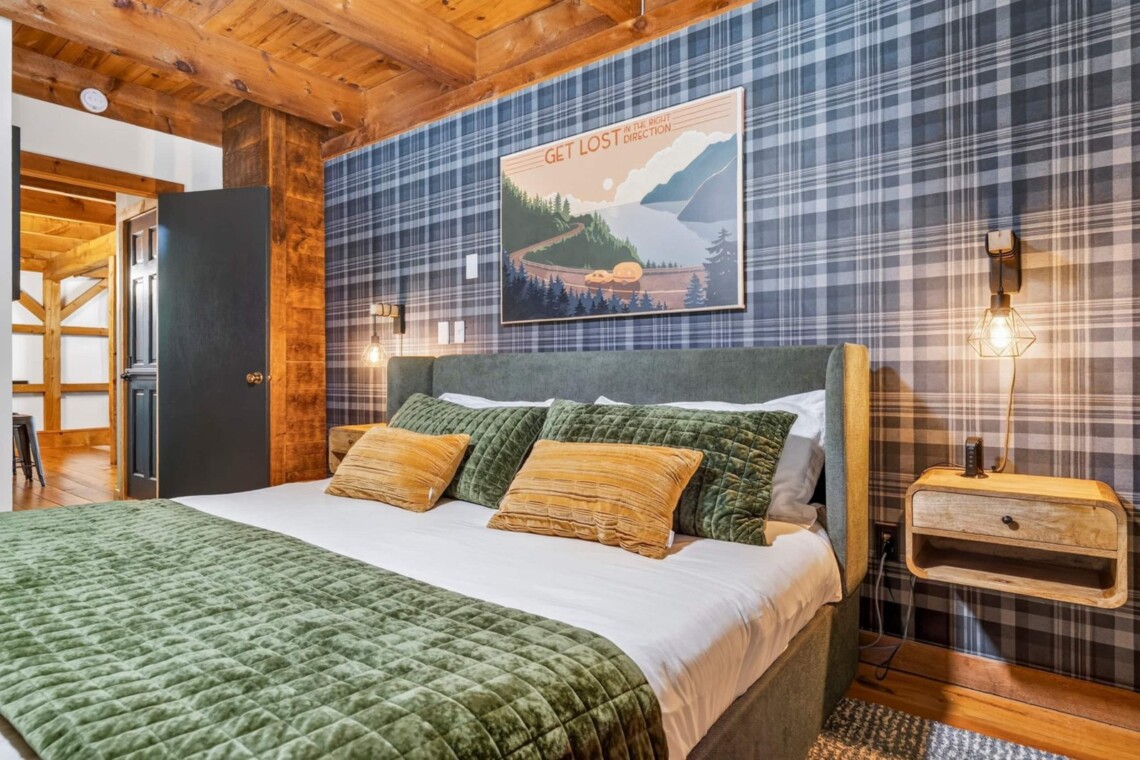 Bedroom with plaid accent wall, upholstered bed and lake art print