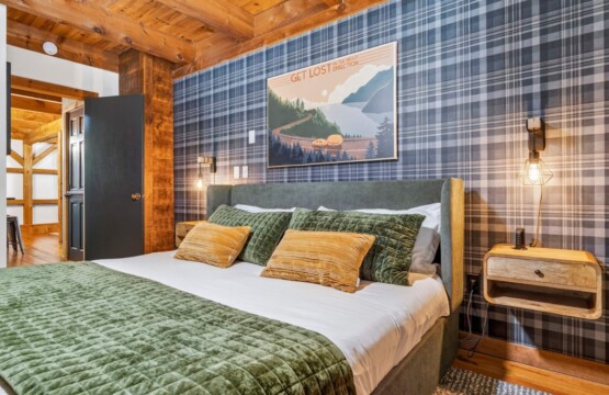 Bedroom with plaid accent wall, upholstered bed and lake art print