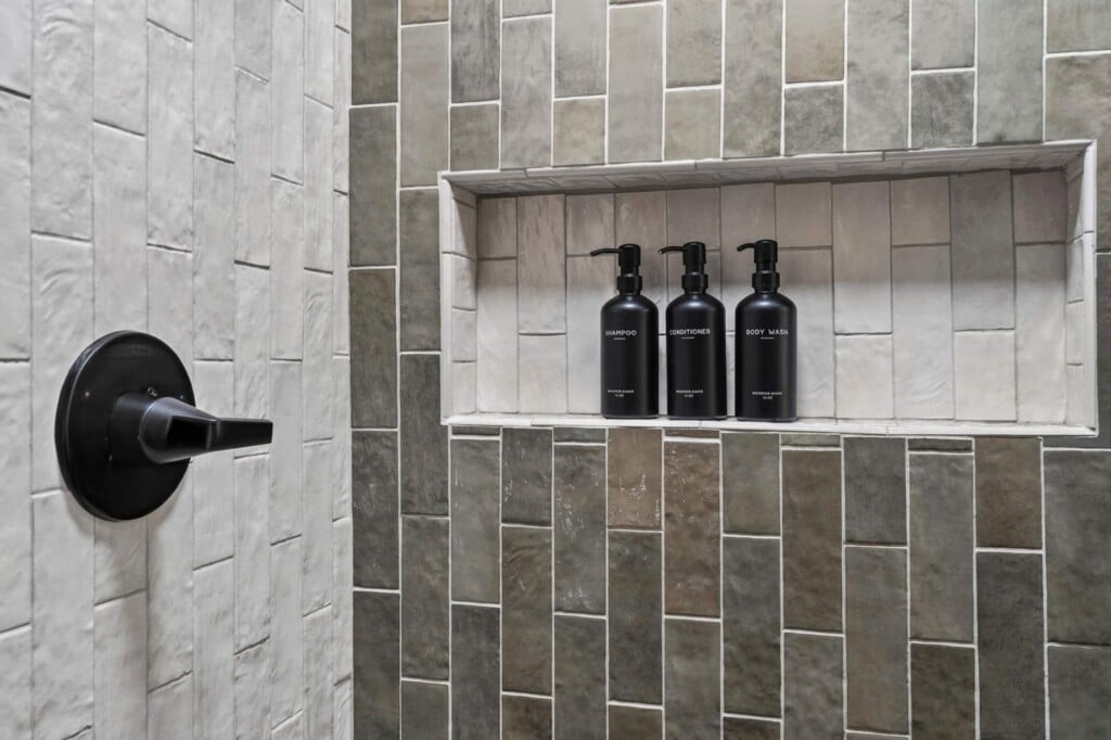 Tiled shower niche with shampoo, conditioner and body wash bottles