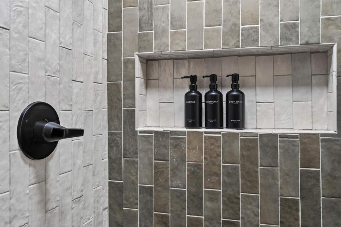 Tiled shower niche with shampoo, conditioner and body wash bottles