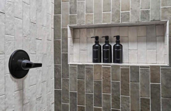 Tiled shower niche with shampoo, conditioner and body wash bottles