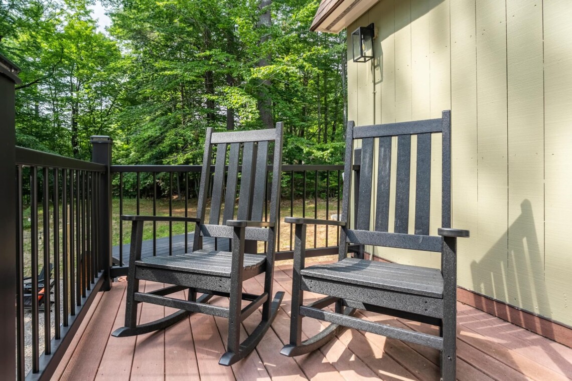 Two black rocking chairs on the front porch at Peak & Pine Retreat