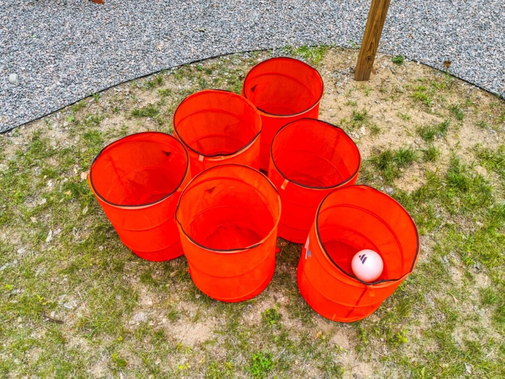 Giant yard pong buckets set up on the lawn at Peak & Pine Retreat