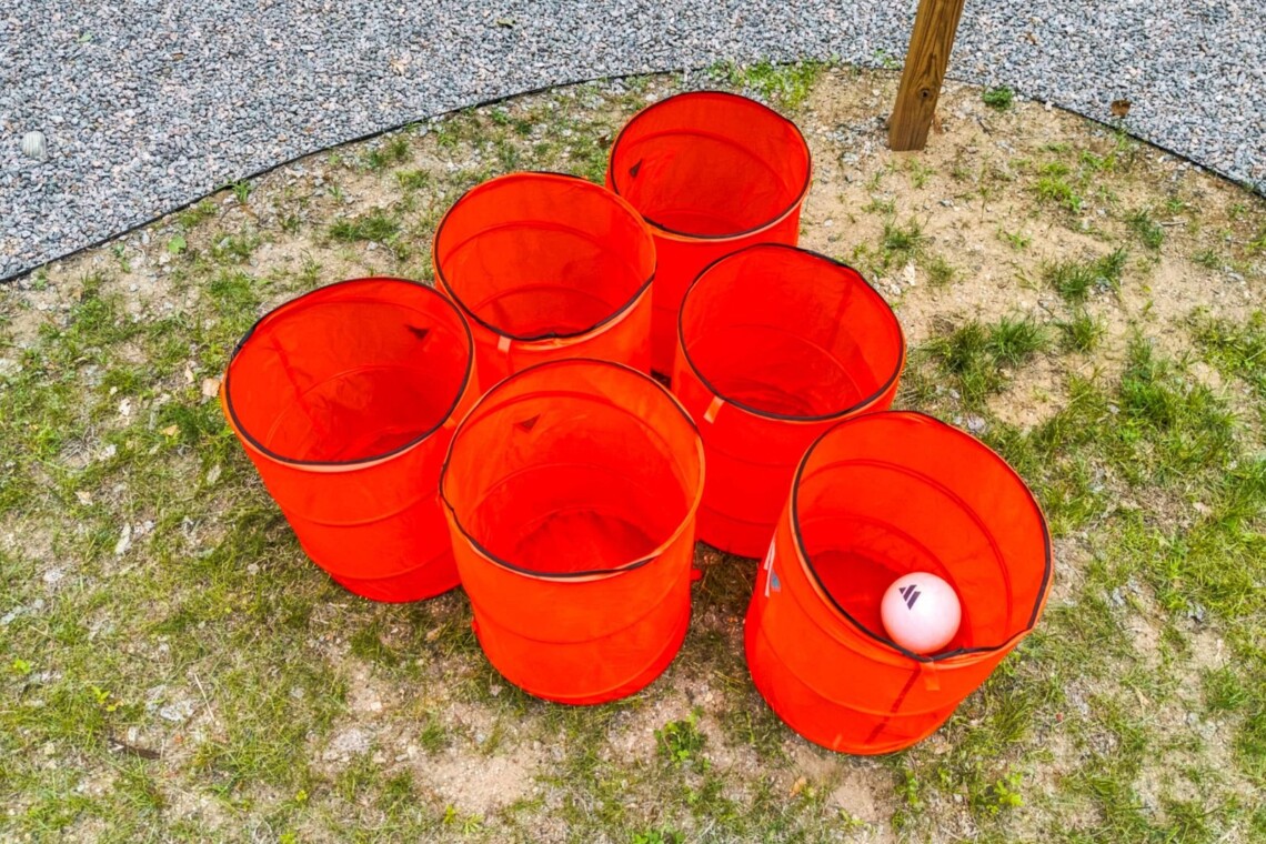 Giant yard pong buckets set up on the lawn at Peak & Pine Retreat