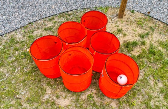 Giant yard pong buckets set up on the lawn at Peak & Pine Retreat